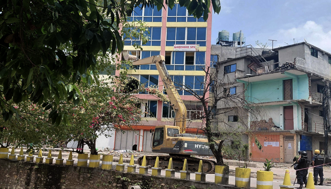 भत्काउने कार्य सुरु : धोबी खोला किनारको सार्वजनिक जग्गामा बनेको ८ तले भवनमा डोजर